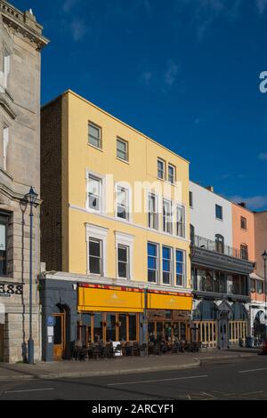 Ramsgate, England - 17. Januar 2020 Das markante gelbe und orangefarbene Gebäude des Restaurants Little Ships an der Hafenfront in Ramsgate, gegen eine bri Stockfoto