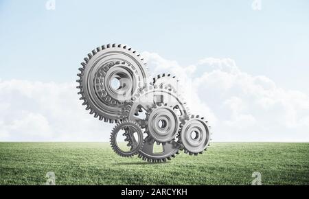 Abstrakte Mechanismus mit Zahnräder auf der grünen Wiese Stockfoto