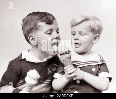 DREISSIGER JAHRE ZWEI JUNGEN BRÜDER, DIE SICH TEILEN, DOPPELTE DIP-SCHOKOLADE UND VANILLEEISKEGEL ZU ESSEN - F4272 HAR001 HARS MÄNNER RISKIEREN GESCHWISTER B&W DIP VANILLE FLECKKOPF UND SCHULTERN UND ERNÄHRUNGSKEGEL GESCHWISTERVERBINDUNG KONZEPTIONELL KONSUMIEREN NAHRUNG STILVOLLES EIS ZUSAMMENARBEIT WACHSTUM JUGENDLICHE LECKEN ERFRISCHEND SCHMACKHAFTE ZWEISAMKEIT SCHWARZ UND WEISS KAUKASISCHE ETHNIE HAR001 ALTMODISCH Stockfoto