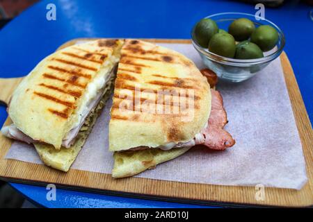 Italienisches Panino auf Holzbrett mit Oliven Stockfoto