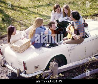 SECHZIGER JAHRE GRUPPE 6 STYLISCHE TEENAGER AUF WEISSEM TRIUMPH CABRIOLET MIT PICKNICKKORB HÖREN KIND SPIELEN GITARRE - KJ5089 PHT001 HARS VEHICLE GEFIEL FREUDE LIFESTYLE SOUNDMUSIKER FRAUEN LÄNDLICHE GESUNDHEIT HEIM LEBEN 6 NATUR KOPIE RAUM FREUNDSCHAFT HALBE LÄNGE PERSONEN INSPIRATION AUTO MÄNNER TEENAGER SECHS TEENAGER UNTERHALTUNG TRANSPORT GLÜCK FRÖHLICHES ABENTEUER IN HOHEM WINKEL FREIZEIT AUTOS SPANNUNG ERHOLUNG HERBST SAISON LÄCHELT MUSIKINSTRUMENT VERBINDUNG AUTOMOBILE FRÖHLICH STILVOLL TEENAGER FAHRZEUGE WACHSTUM JUGENDLICHE ZUSAMMENLEBEN TRIUMPH HERBSTLICHE KAUKASISCHE ETHNIE Stockfoto