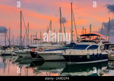 Atemberaubende Aussicht auf Luxus Yachten am Pier vor dem Sonnenuntergang. Yachten und Boote in der Marina verankert. Stockfoto