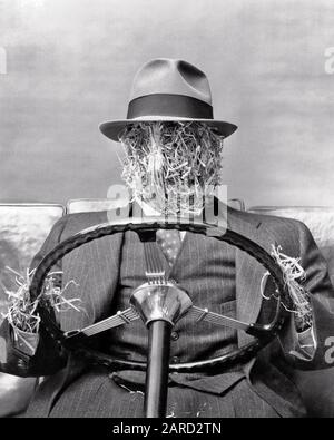 1930ER-JAHRE STROHMANN FUHR EIN AUTO MIT DREITEILIGER ANZUGWESTE, DIE MIT STROHHALMEN AM LENKRAD HÄLT - S8464 HAR001 HARS LENKRAD SCAM ÄHNLICH MADE CONCEPT DREITEILIGER ANZUG KONZEPT STILLLEBEN AUTOMOBILE SYMBOLIC ARGUMENTIERT KONZEPTE FIKTIVE INFORMELLE PROPOSITION STROHMANN SCHWARZ UND WEISSE HAR001-ALTMODISCHE DARSTELLUNG Stockfoto
