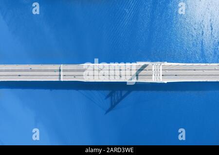 Lange Brücke über großen Fluss oder Meeresantenne mit langem Schatten Stockfoto