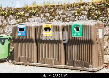 Vila Cha bei Esposende, Portugal - 9. Mai 2018: Öffentliche Recyclingbehälter vor einer Steinmauer in der Innenstadt an einem Frühlingstag Stockfoto