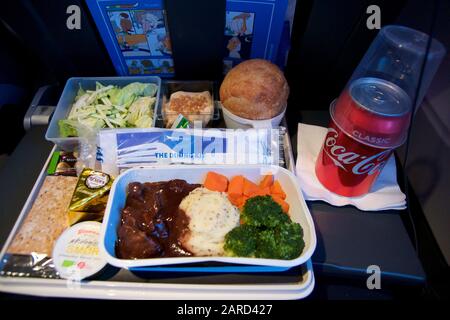 SAN FRANCISCO, California, United States - Jun 24th, 2018: warmes Essen an Bord der Economy Class Flugzeug am Tisch serviert mit Salat und Cola Stockfoto