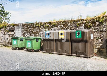 Vila Cha bei Esposende, Portugal - 9. Mai 2018: Öffentliche Recyclingbehälter vor einer Steinmauer in der Innenstadt an einem Frühlingstag Stockfoto