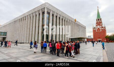 Die Menge der Touristen, die im staatlichen Kremlpalast, auch Kremlpalast der Kongresse genannt, und der Troitskaja-Turm zu sehen sind. Moskau, Russland. Stockfoto