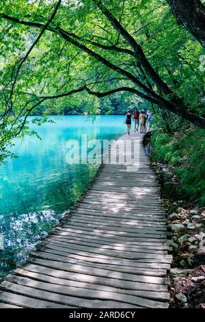 Touristen erkunden die Holzstege im Nationalpark Plitvicer Seen in Kroatien Stockfoto