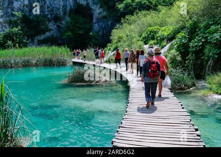 Touristen erkunden die Holzstege im Nationalpark Plitvicer Seen in Kroatien Stockfoto