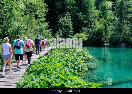 Touristen erkunden die Holzstege im Nationalpark Plitvicer Seen in Kroatien Stockfoto