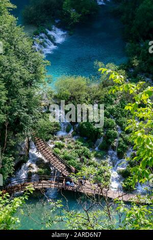 Touristen erkunden die Holzstege im Nationalpark Plitvicer Seen in Kroatien Stockfoto