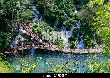 Touristen erkunden die Holzstege im Nationalpark Plitvicer Seen in Kroatien Stockfoto