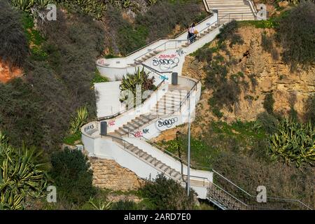 Steile Steinstufen auf der Klippe, die hinunter zum Strand von Praia da Rocha, Algarve, Portugal führt Stockfoto