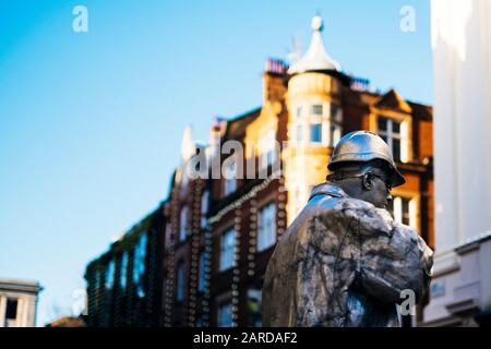 Ein Street-Performer balanciert auf einem Spatenstich in Covent Garden, London Stockfoto