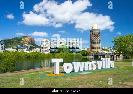 Schild Townsville am Ufer des Ross River mit der Skyline der Stadt und dem Castle Hill im Hintergrund. Central Park, Townsville Queensland. Stockfoto