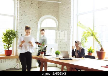 Konzentriert. Portrait einer schönen arabischen Geschäftsfrau, die während ihrer Arbeit in Openspace oder Büro einen Hijab trägt. Berufskonzept, Freiheit im Geschäftsfeld, Führung, Erfolg, moderne Lösung. Stockfoto