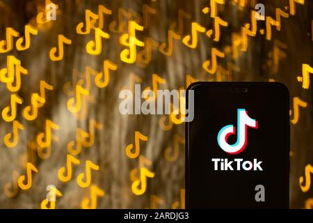 TikTok App-Logo auf Smartphone und Bokeh in Form von TikTok im Hintergrund. Keine Montage. Keine Fotobearbeitung. Es wird eine benutzerdefinierte Bokeh-Shape-Technik verwendet. Stockfoto