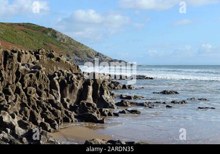 Erodierte karbonifere Kalkfelsen am Strand von Caswell Bay bei Mumbles auf der Halbinsel Gower, in der Nähe von Swansea, Wales, Großbritannien Stockfoto