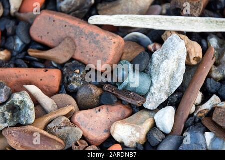 Ein Flaschenhals aus Strandglas, der zwischen Ziegelfragmenten, Kohlelabeln und alten Tierknochen auf der Themse vor der Küste von London, Großbritannien, gespült wurde. Stockfoto