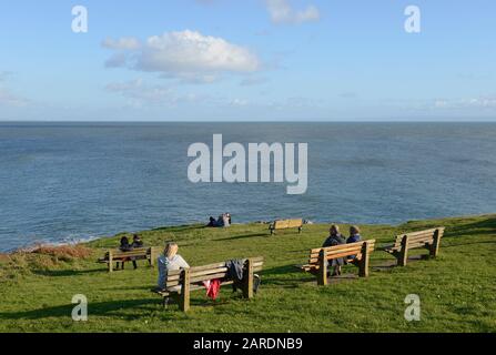 Besucher bewundern den Blick vom Hügel neben der Bucht von Langland auf der Halbinsel Gower bei Swansea in Wales, Großbritannien Stockfoto