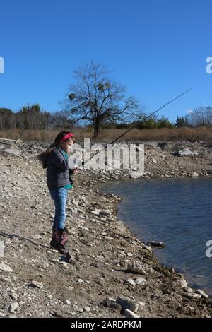 Kinderangeln im Winter in einem Wasserloch Stockfoto