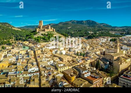 Luftbild der Burg Biar in der Provinz Valencia Spanien mit Donjon über der Stadt und konzentrischen Wänden, die mit halbrunden Türmen verstärkt wurden Stockfoto