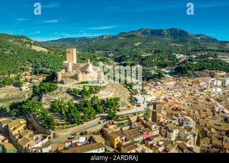 Luftbild der Burg Biar in der Provinz Valencia Spanien mit Donjon über der Stadt und konzentrischen Wänden, die mit halbrunden Türmen verstärkt wurden Stockfoto