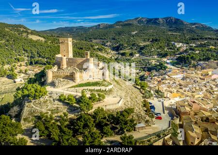 Luftbild der Burg Biar in der Provinz Valencia Spanien mit Donjon über der Stadt und konzentrischen Wänden, die mit halbrunden Türmen verstärkt wurden Stockfoto