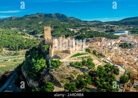 Luftbild der Burg Biar in der Provinz Valencia Spanien mit Donjon über der Stadt und konzentrischen Wänden, die mit halbrunden Türmen verstärkt wurden Stockfoto