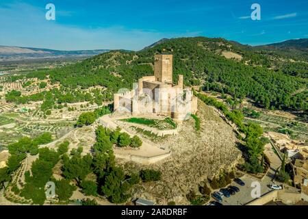 Luftbild der Burg Biar in der Provinz Valencia Spanien mit Donjon über der Stadt und konzentrischen Wänden, die mit halbrunden Türmen verstärkt wurden Stockfoto