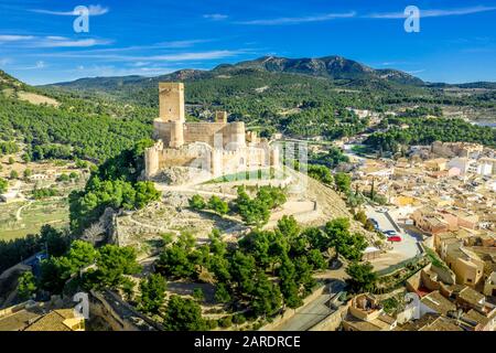 Luftbild der Burg Biar in der Provinz Valencia Spanien mit Donjon über der Stadt und konzentrischen Wänden, die mit halbrunden Türmen verstärkt wurden Stockfoto