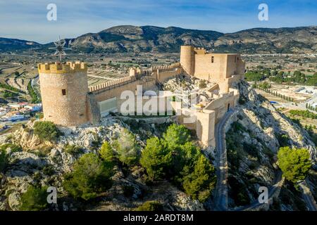 Luftbild der Burg Castalla in der Provinz Valencia Spanien mit Donjon, der über die Stadt ragt, und einem Innenhof, der mit einem runden Turm an einer Sonne verstärkt wurde Stockfoto