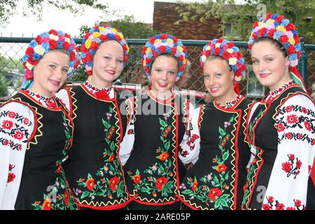 Lächelnde Tänzerinnen, gekleidet in traditionellem rot-ukrainischem gesticktem Kostüm Stockfoto