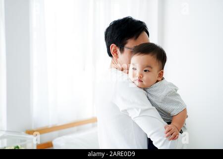 Glücklicher asiatischer Vater und Kleinkind zu Hause, die gemeinsame Familienzeit genießen Stockfoto