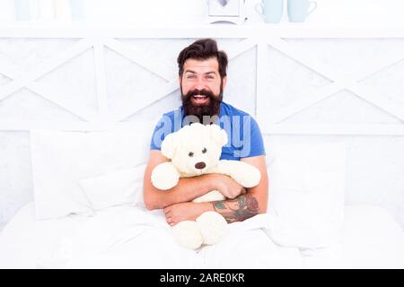 Bärtiger Teddybär im Bett. Plüschspielzeugkonzept. Geschenk für den Urlaub. Für Sie präsent. Valentines Tagesgeschenk für geliebte. Feiertagsfeier. Mein Geburtstag. Frohes Erwachsenenalter. Großhandel. Liebe und Freundlichkeit. Stockfoto