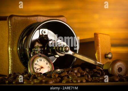 Coffee Bean und Taschenuhr. Manuelle Schleifer auf Tabelle am Morgen. Konzept der Kaffee Zeit. Stockfoto