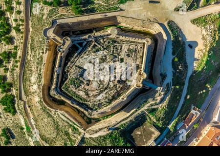 Luftaufnahme der Burg Chinchilla de Montearagon mit dem zerstörten, ausgegrabenen inneren Gebäude bleibt von einer Außenmauer mit halbrunden Türmen umgeben Stockfoto