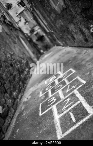 Vertikale Aufnahme einer Gasse mit Hopscotch bemalt auf der Masse Stockfoto