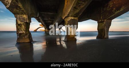 Weite Aufnahme einer alten kaputten Brücke über das Meer Stockfoto