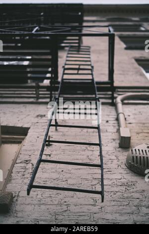 Senkrechter niedriger Winkel Aufnahme der metallischen Leiter auf a Gebäude Stockfoto