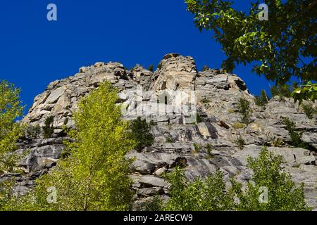 Die riesigen und schönen Wände aus Granit der Tetons Canyons sind atemberaubend gegen einen strahlend blauen Himmel. Stockfoto