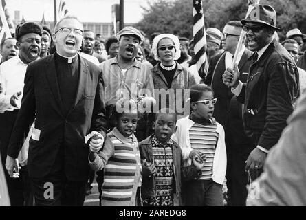 Frontlinie des Selma zu Montgomery March mit Dr. und Mrs. Martin Luther King (Mitte), Dr. und Mrs. Ralph David Abernathy (mit ihren Kindern Donzaleigh, Ralph David und Juandalynn) und John Lewis im März 1965. (Der Name des weißen Ministers ist unbekannt.) Stockfoto