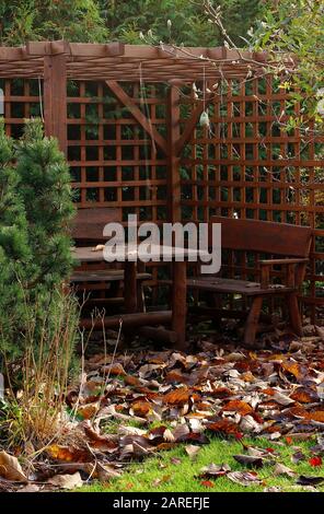 Pergola mit Tisch und Stühlen im Herbstgarten Stockfoto