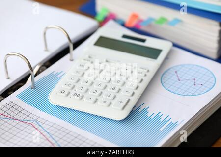 Weißer Caculator mit Business Chart liegt im Büro Stockfoto