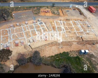 Unterteilung Häuser und geplante Öko-Wohnbau Entwicklung Luftbild mit Betonschalung, Bäume und Asphaltstraße in Victoria, Australien. Stockfoto