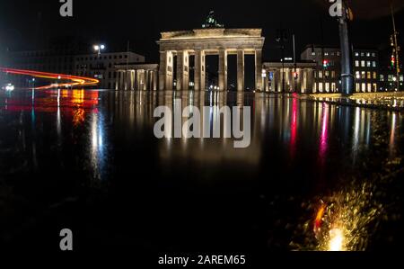 Berlin, Deutschland. Januar 2020. Das Brandenburger Tor spiegelt sich in einer Regenpfütze wider. Credit: Paul Zinken / dpa / Alamy Live News Stockfoto