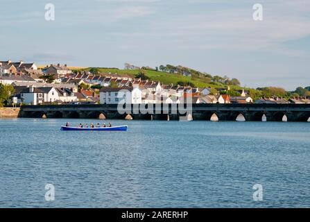 Ein Ruderboot am Ufer des Flusses Torridge am Kai von Bideford, mit der alten Brücke im Hintergrund, South West, North Devon, Großbritannien Stockfoto