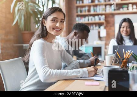 Nahaufnahme der positiven, gemischten Rassendame, die an einem Geschäftstreffen teilnimmt Stockfoto