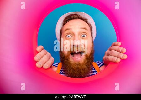 Nahaufnahme überraschter Seemann beobachtet, wie der rosafarbene runde Ring Rettungsboje Scream Wow omg den weißen Stil der modischen maritimen Weste trägt Stockfoto